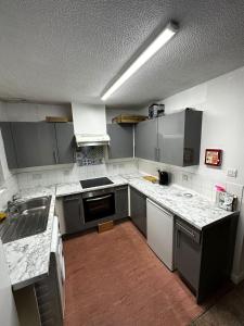 a kitchen with gray cabinets and white counter tops at 2 Bedroom Apartment - 11 Parry Court in Nottingham
