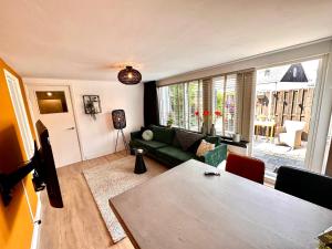 a living room with a green couch and a table at Residentie de Eikhof in Hengelo