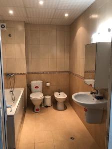 een badkamer met een toilet, een bidet en een wastafel bij Flora Beach Private in Pomorie