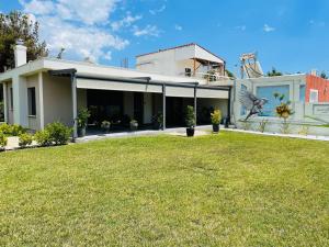 una casa con césped delante en Aurelia Home en Alejandrópolis