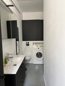 uma casa de banho com um lavatório e uma máquina de lavar roupa em Loft avec jardin chez l'habitant em Bagnolet