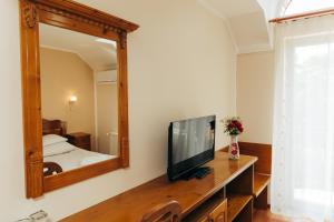 a living room with a television and a mirror at Vila Carmen-camere de închiriat 3 stele in Baile Unu Mai