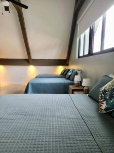 1 dormitorio con 2 camas y 2 ventanas en Villa Blue Moon en Bon Accord