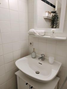 a white bathroom with a sink and a mirror at Ferienwohnung Sandkastenliebe Villa Düringshof in Dornum