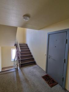 um quarto vazio com uma escada e uma porta em Cozy Sigulda Apartment em Sigulda