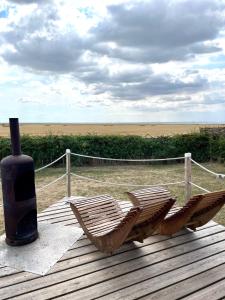 twee stoelen en een vaas op een houten terras bij Lushna 11 Lux Suite at Lee Wick Farm Cottages & Glamping in Clacton-on-Sea