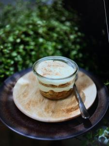 ein Glas Essen auf einer Holzplatte mit einem Löffel in der Unterkunft Bienvenue Chez Nous in Bergues