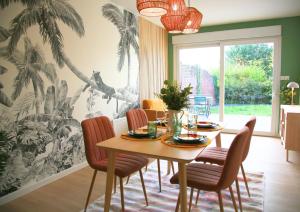 ein Esszimmer mit einem Holztisch und Stühlen in der Unterkunft L'Eden Chic - Balneo - Jardin - Parking gratuit in Arras