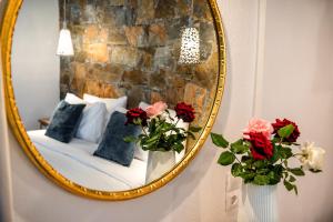 a mirror on a wall with a bed and flowers at Leyla Luxury Villa in Pláka