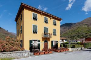un edificio giallo con persiane verdi di Lucca Franco's Villa a Diecimo
