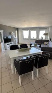 ein Wohnzimmer mit einem weißen Tisch und Stühlen in der Unterkunft Apartment "oceanview" in Lubmin