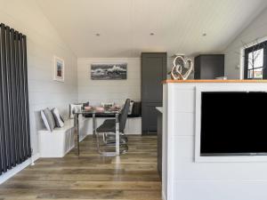 a living room with a table and a tv at Oakwood 2 Pinewood Retreat in Lyme Regis