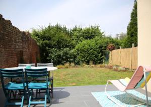 eine Terrasse mit einem Tisch und Stühlen sowie einem Hof in der Unterkunft L'Eden Chic - Balneo - Jardin - Parking gratuit in Arras