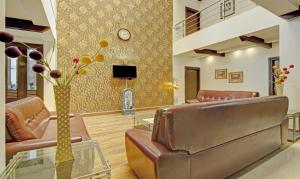 a living room with leather furniture and a tv at Blue Moon Residency Hotel & Restaurant in Gurgaon
