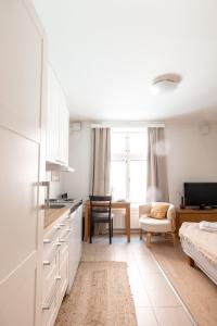 a kitchen with white cabinets and a living room at 2ndhomes Compact Studio by the Esplanade Park in Helsinki