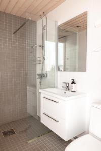 a white bathroom with a sink and a shower at 2ndhomes Compact Studio by the Esplanade Park in Helsinki