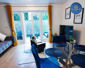 uma sala de estar com cadeiras azuis e uma televisão em 2 Bedroom House By Cabral Properties Monthly special price em Reading