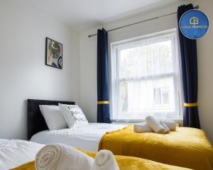 um quarto com 2 camas e uma janela em 2 Bedroom House By Cabral Properties Monthly special price em Reading