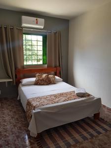 um quarto com 2 camas e uma janela em Pouso Tião da Morena em Pirenópolis