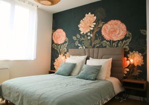 um quarto com uma cama grande e papel de parede floral em L'Eden Chic - Balneo - Jardin - Parking gratuit em Arras