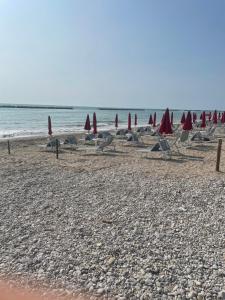 a group of chairs and umbrellas on a beach at Residence Verde Mare in Massignano