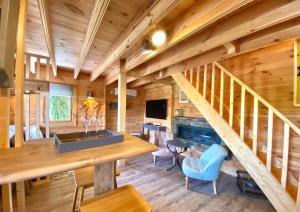 a log home with a staircase and a living room at La Maison de Manolie in Courcelles-Sapicourt