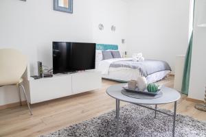 Dormitorio blanco con cama y mesa con TV en Etoile City Center Apartments en Belgrado