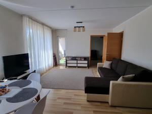uma sala de estar com um sofá e uma mesa em Cozy Sigulda Apartment em Sigulda