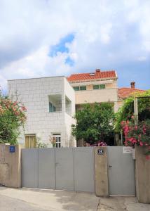 a house with a fence in front of a building at AVA Studio apartment and Room in Dubrovnik