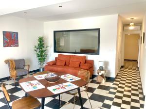 ein Wohnzimmer mit einer Couch und einem Tisch in der Unterkunft Appartement avec vue sur le port in Sète + 3 Fotos
