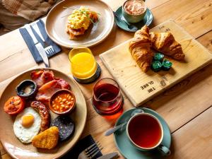 una mesa con platos de desayuno y una taza de té en Calthwaite Hall Bed & Breakfast en Penrith