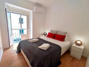 Un dormitorio blanco con una cama grande con almohadas rojas en Red Passion Apartment, en Lisboa