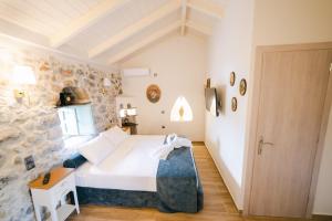 a bedroom with a bed and a stone wall at LA TORE DI MONTENEGRO in Gythio