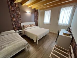 Habitación pequeña con 2 camas y escritorio. en Agriturismo Corte Ambrosio, en Pozzolengo