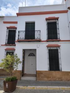 um edifício branco com janelas e uma porta em Casa SANTA MARÍA em Carmona