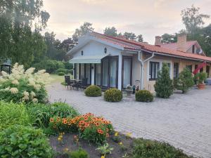 una casa con patio y flores frente a ella en Villa Leonardo, en Ventspils