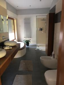 a bathroom with two sinks and a tub and a shower at Apartament przy lesie in Chojno