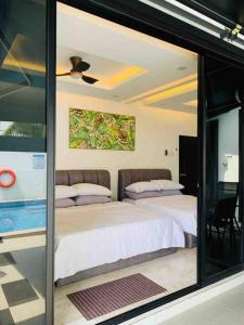 - une chambre avec 2 lits et une fenêtre en verre dans l'établissement Abbie's Private Pool Villa Bukit Mertajam Penang, à Bukit Mertajam