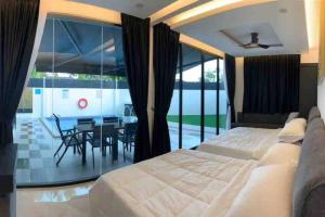 1 dormitorio con 1 cama y 1 mesa con sillas en Abbie's Private Pool Villa Bukit Mertajam Penang en Bukit Mertajam