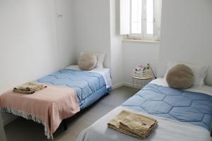 エヴォラにあるCasa das Nobresのベッド2台と窓が備わる客室です。