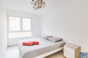 ein weißes Schlafzimmer mit einem Bett und einem Kronleuchter in der Unterkunft Beautiful Appartement & Parking - Vieux-Port in Marseille