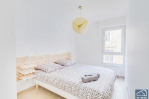 ein weißes Schlafzimmer mit einem Bett und einem Fenster in der Unterkunft Beautiful Appartement & Parking - Vieux-Port in Marseille