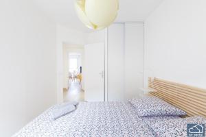 ein weißes Schlafzimmer mit einem Bett und einer Lampe in der Unterkunft Beautiful Appartement & Parking - Vieux-Port in Marseille
