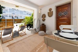 a dining room with a table and chairs and a balcony at The 98 Place Carcavelos in Carcavelos