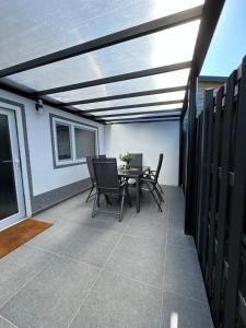 eine Terrasse mit Tisch und Stühlen auf einem Gebäude in der Unterkunft Ferienvilla 10 Minuten vom Strand in Dirkshorn