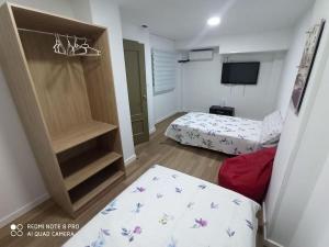 Habitación pequeña con 2 camas y TV. en Apartamento vacacional, en Torrevieja