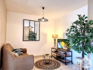 sala de estar con sofá y planta en Perle des Camélias-T2 classé 3 étoiles sur Saint-Denis, en Saint-Denis