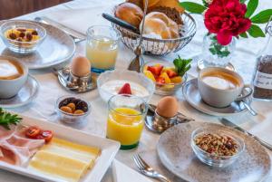 a table topped with plates of breakfast foods and drinks at Garni Pramstrahler in Chiusa