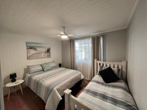 1 dormitorio con 2 camas, mesa y ventana en Seamist @ Scotts Head, en Scotts Head