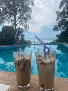 two drinks sitting on a table next to a pool at Zuri Kvariati in Kvariati